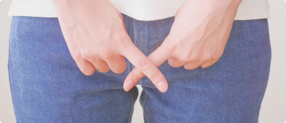デニムを履いた女性が両手の指を交差させている様子