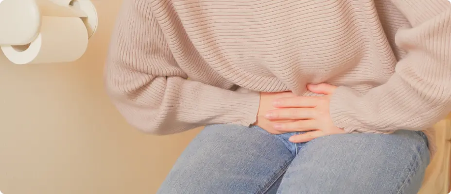 お腹を両手で押さえる女性の様子