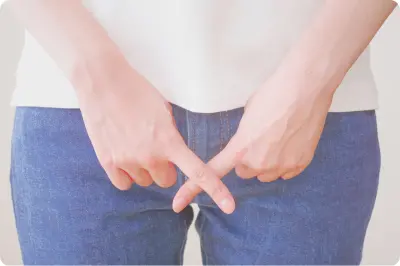 お腹の前で手を重ねる女性