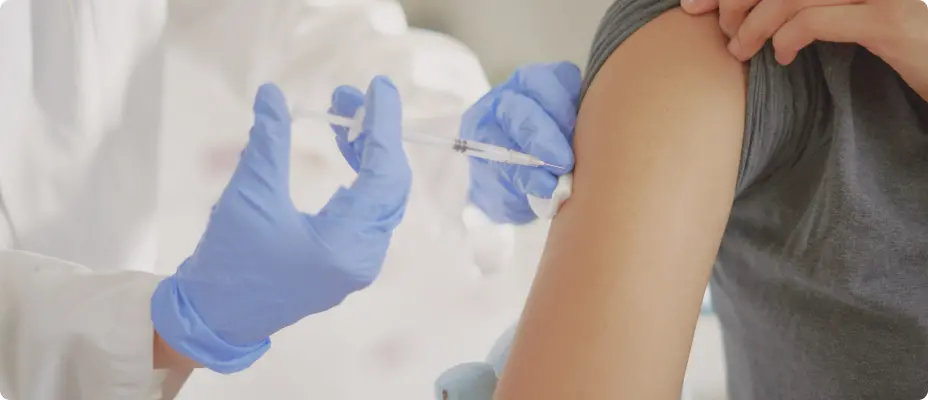 医師が女性の腕にワクチンを接種している様子